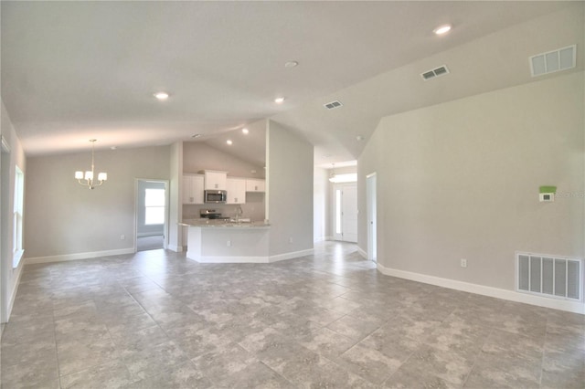 unfurnished living room featuring high vaulted ceiling and a chandelier