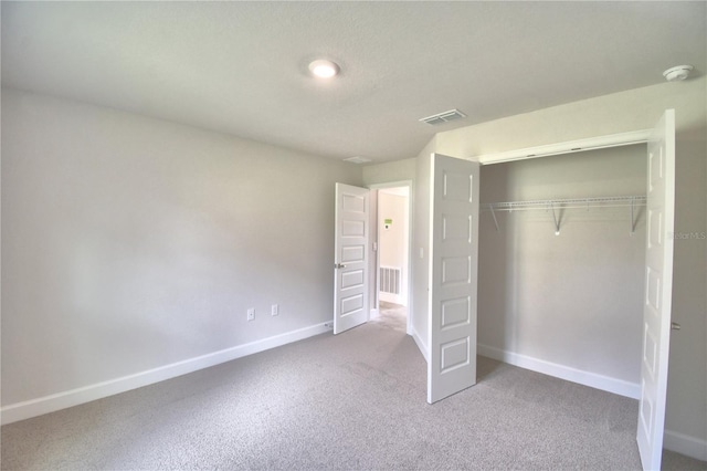 unfurnished bedroom featuring light carpet and a closet