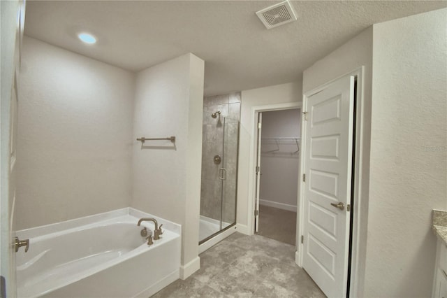 bathroom featuring separate shower and tub, vanity, and a textured ceiling