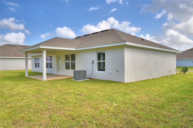 rear view of property with a patio, central air condition unit, and a lawn