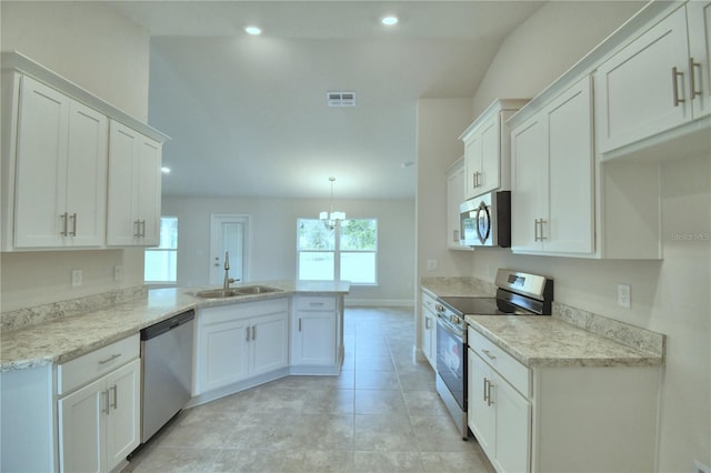 kitchen featuring white cabinetry, sink, kitchen peninsula, decorative light fixtures, and appliances with stainless steel finishes