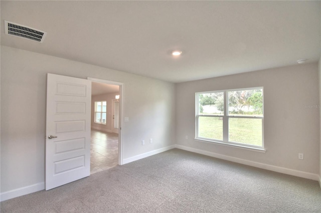 carpeted empty room featuring plenty of natural light