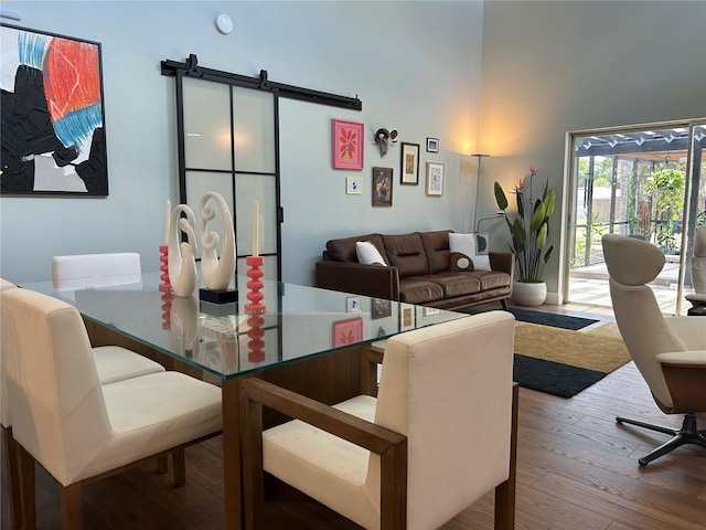 dining space featuring hardwood / wood-style flooring and a barn door