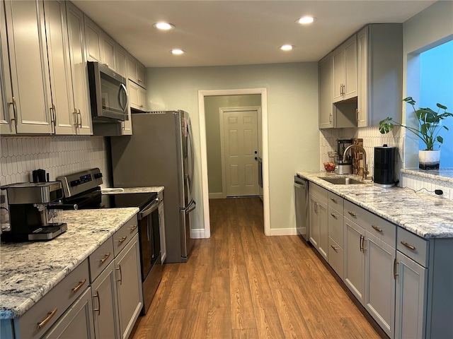 kitchen featuring stainless steel appliances, gray cabinets, dark wood-type flooring, and sink