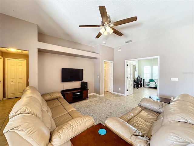 living room featuring ceiling fan, light tile patterned floors, and a textured ceiling