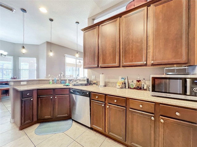 kitchen featuring kitchen peninsula, appliances with stainless steel finishes, sink, light tile patterned floors, and pendant lighting