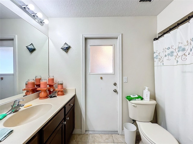 bathroom featuring plenty of natural light, vanity, a textured ceiling, and tile patterned flooring