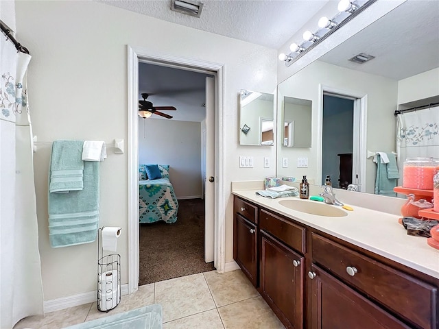 bathroom featuring tile patterned floors, ceiling fan, vanity, and a textured ceiling