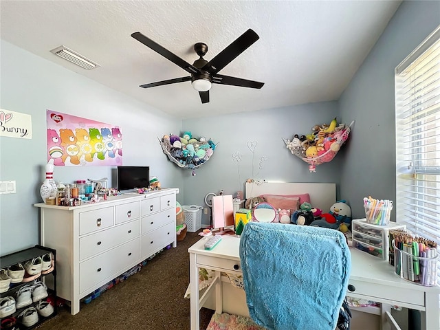 bedroom featuring a textured ceiling, dark carpet, and ceiling fan