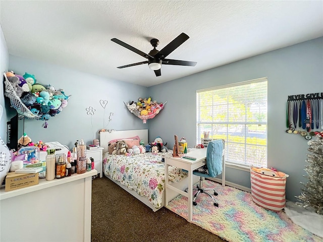 carpeted bedroom featuring ceiling fan and a textured ceiling