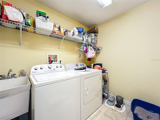 washroom with washing machine and clothes dryer, sink, and light tile patterned floors