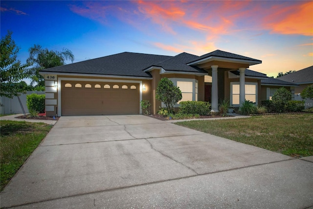 prairie-style house with a garage and a lawn