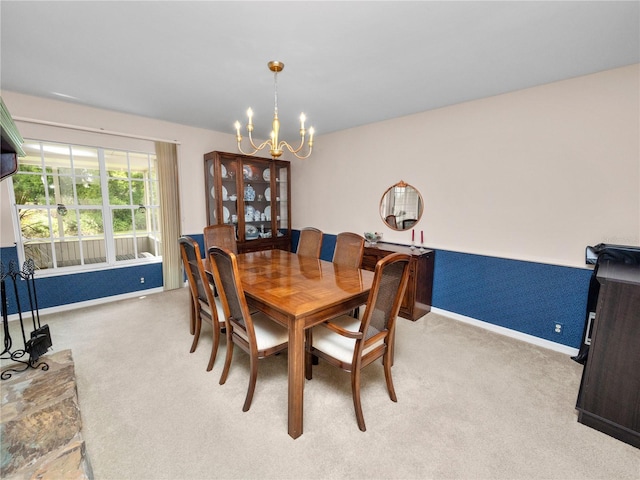 dining room featuring light carpet and a notable chandelier