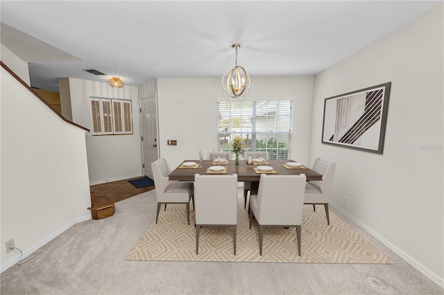 carpeted dining space with an inviting chandelier