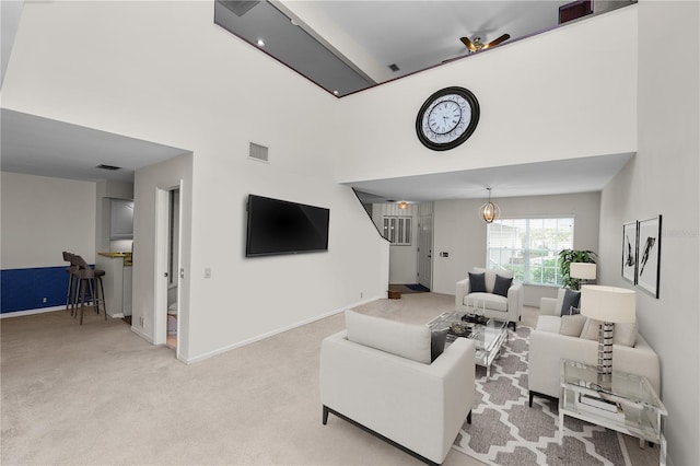 carpeted living room featuring a high ceiling and an inviting chandelier