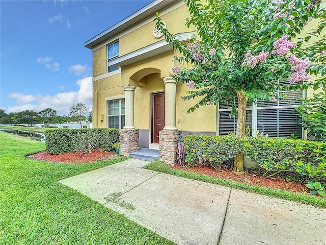 view of exterior entry with a yard