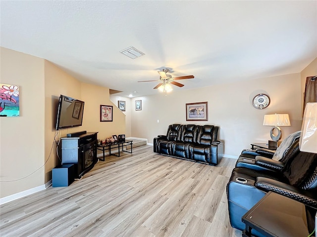 living room featuring light hardwood / wood-style flooring and ceiling fan