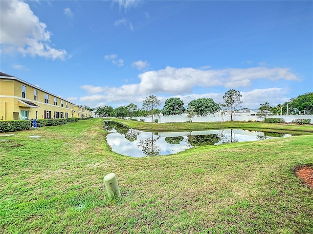 view of home's community featuring a water view and a lawn