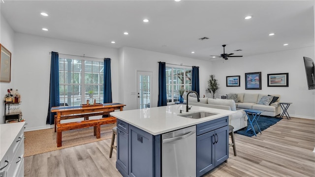 kitchen featuring a kitchen breakfast bar, an island with sink, stainless steel dishwasher, and sink