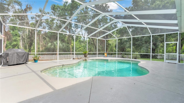 view of pool featuring glass enclosure, a patio area, and a grill