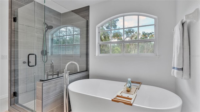 bathroom featuring shower with separate bathtub