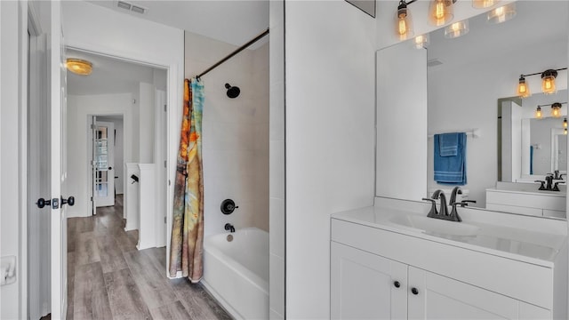 bathroom with vanity, wood-type flooring, and shower / tub combo