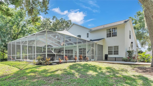 rear view of property featuring a lawn, glass enclosure, and a patio area