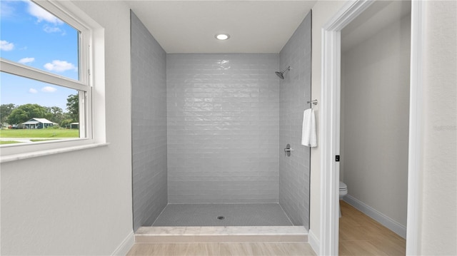 bathroom featuring toilet and tiled shower