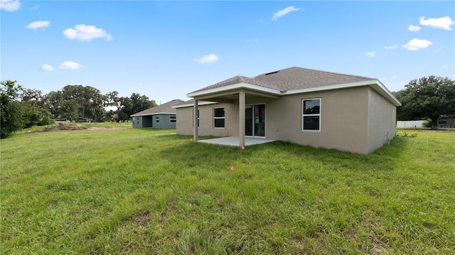 rear view of property featuring a yard and a patio