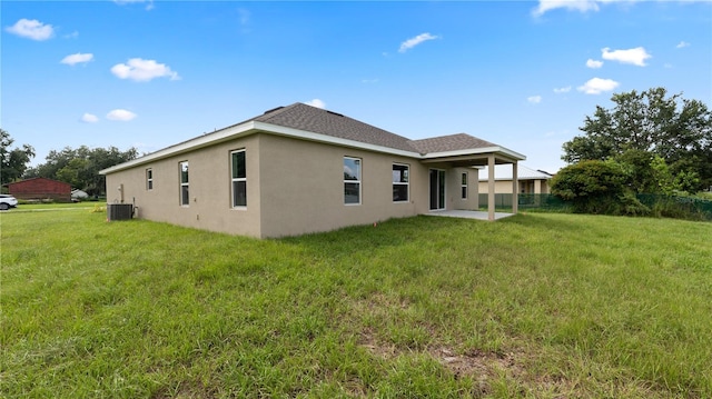 back of property with a patio, central air condition unit, and a lawn