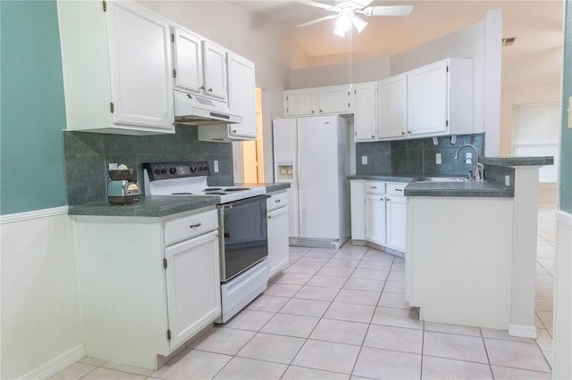 kitchen with white appliances, dark countertops, white cabinets, and under cabinet range hood