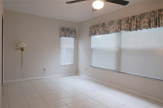 empty room with ceiling fan and baseboards