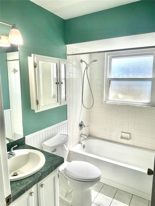 full bath featuring wainscoting, toilet,  shower combination, tile patterned flooring, and vanity