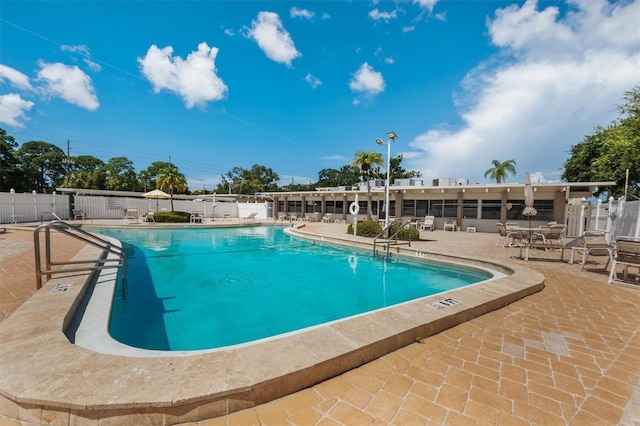 pool featuring fence and a patio