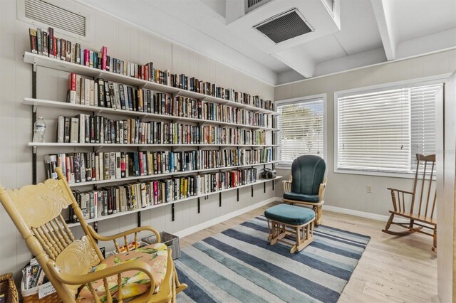 living area featuring light hardwood / wood-style floors and beamed ceiling