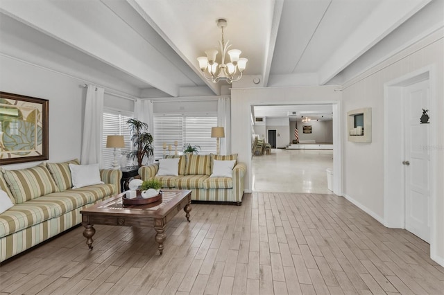 living area featuring baseboards, beamed ceiling, an inviting chandelier, and wood finished floors