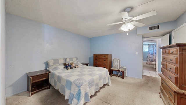 bedroom with a textured ceiling, light colored carpet, and ceiling fan