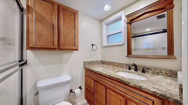 bathroom featuring vanity, toilet, and walk in shower