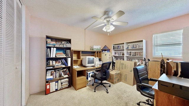 carpeted home office featuring ceiling fan and a textured ceiling