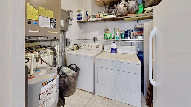 laundry room featuring washer and dryer, light tile patterned floors, and water heater