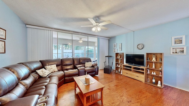 living room featuring ceiling fan, wood-type flooring, and a textured ceiling