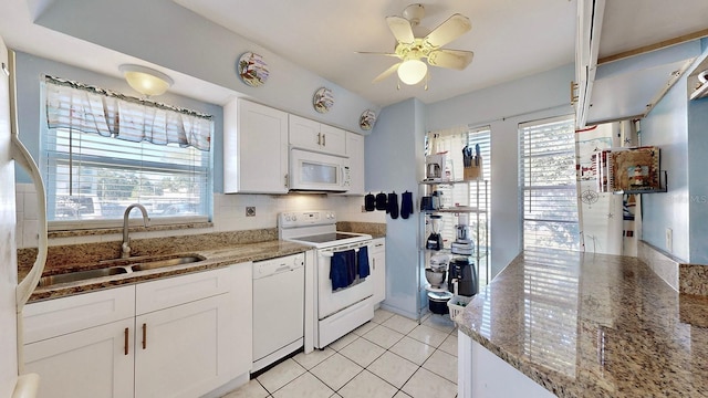 kitchen featuring white cabinetry, light tile patterned flooring, stone counters, sink, and white appliances