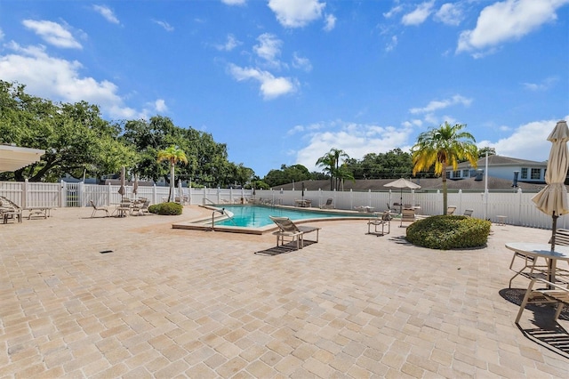 community pool featuring fence and a patio