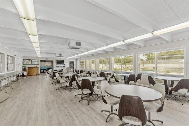 dining space featuring light hardwood / wood-style floors and beam ceiling