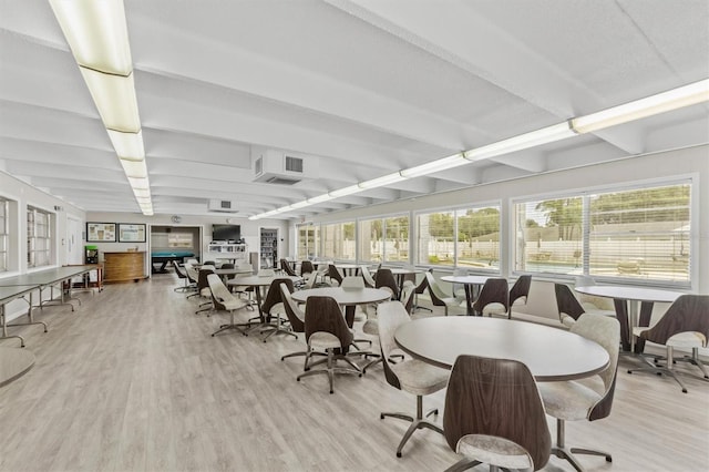 dining room with light wood-style floors and beamed ceiling