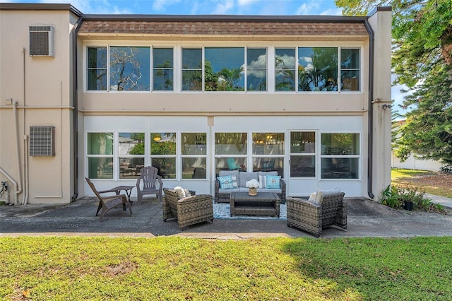 back of property featuring a patio, outdoor lounge area, stucco siding, and a yard