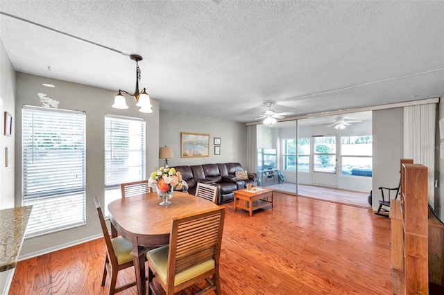 dining room with a textured ceiling, light wood-style flooring, and a ceiling fan