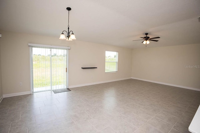 empty room featuring ceiling fan with notable chandelier