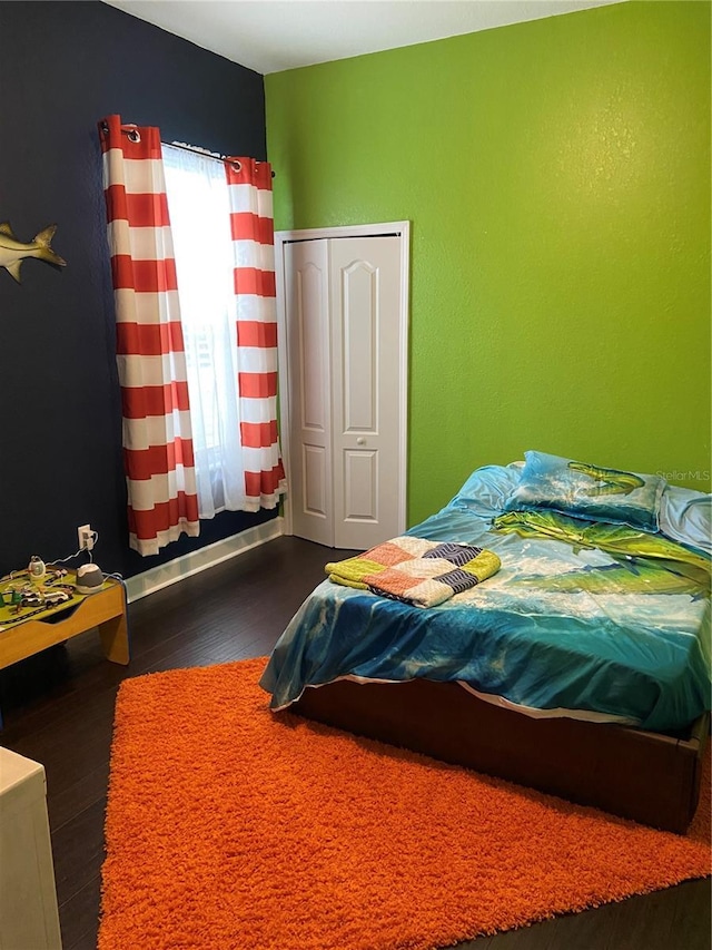 bedroom with a closet and dark wood-type flooring