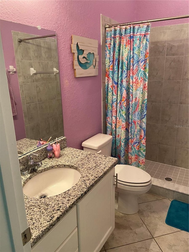 bathroom with tile patterned floors, vanity, toilet, and walk in shower